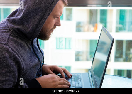 Cyberkriminalität, Hacking und Technologie Konzept - männliche hacker Code schreiben oder über Computer Virus Programm für Cyber Attack Stockfoto