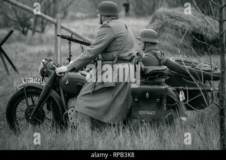 Gomel, Belarus - November 26, 2017: Zwei Soldaten der Bundeswehr in ihrer greatcoats Motorrad fahren auf dem Feld. Wiederaufbau der Kampf um die Stadt Gomel. Schwarz und Weiß Foto Stockfoto