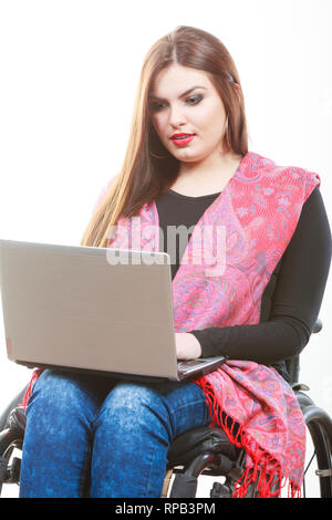 Behinderte Dame Surfen im Web ein. Junge Weibchen auf der Rollstuhl mit Laptop. Internet Technologie Bildung Behinderung Konzept. Stockfoto
