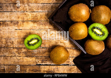 Kiwis auf einem rustikalen Holztisch, Ansicht von oben Stockfoto