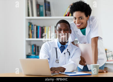 Afrikanische amerikanische Arzt Krankenschwester an Kamera schaut am Krankenhaus Stockfoto