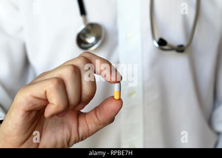 Doktor mit Pille, Medikamente in der Kapsel in männlicher Hand. Konzept der medizinischen Untersuchung, Apotheker, Vitamine, Rezept, Gesundheitswesen Stockfoto