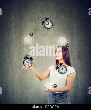 Smart time Management Konzept. Glückliche junge Frau jonglieren hellen Glühbirnen und Wecker Stockfoto