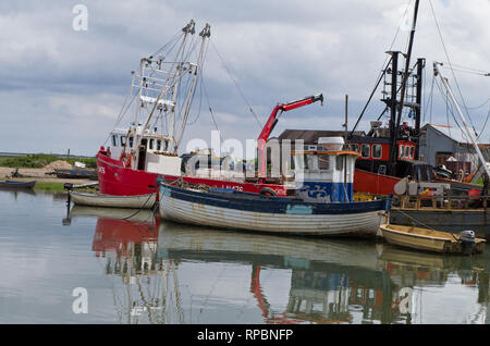 Bunte Fischerboote vor Anker im Hafen von brancaster Staithe, North Norfolk, Großbritannien Stockfoto