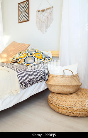 Weiß und Beige Schlafzimmer in boho Style mit macrame an der Wand Stockfoto