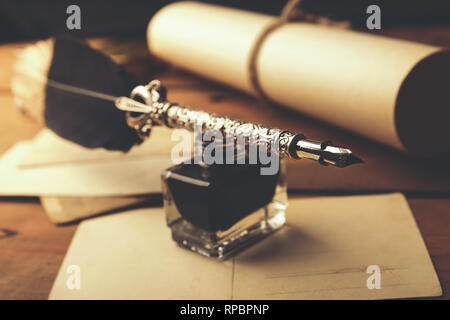 Vintage feather Pen mit Flasche Tinte und alte Papierrolle Stockfoto
