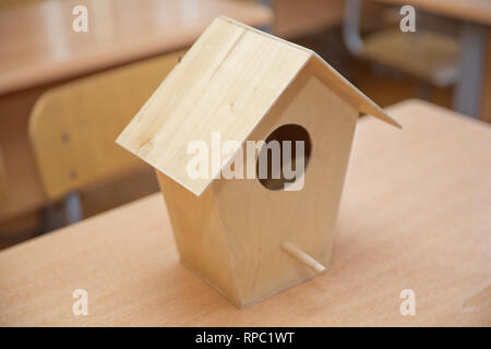 Der hölzerne Vogel Nest. Holz- Vogelhaus. Kleines Vogelhaus hängend inmitten von Niederlassungen Stockfoto