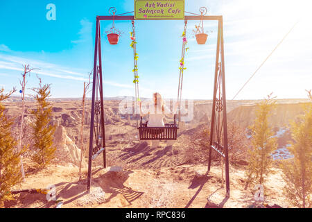 Sorglos Frau auf der Schaukel. Inspirierende Bergwelt. Traum und Freiheit Konzept. Stockfoto