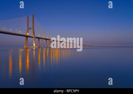 Elegante steel Bridge bei Nacht vorbei an Kilometer über große ruhige Fluss Wasser Stockfoto