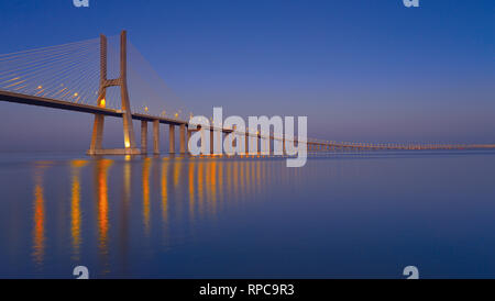 Elegante steel Bridge bei Nacht vorbei an Kilometer über große ruhige Fluss Wasser Stockfoto