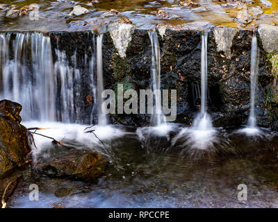 Eine japanische Fluss Kaskaden mehr als ein Abflußkanal in einem Tal in der Nähe der Stadt Isehara in der Präfektur Kanagawa, Japan Stockfoto