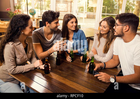 Eine Gruppe von Freunden an der Bar ein Bier trinken Stockfoto