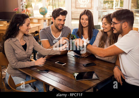 Gruppe von Freunden rumhängen und einen Toast mit Bier Stockfoto