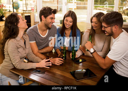 Eine Gruppe von Freunden an der Bar ein Bier trinken Stockfoto