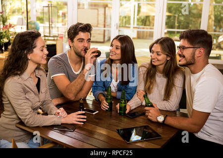 Eine Gruppe von Freunden an der Bar ein Bier trinken Stockfoto