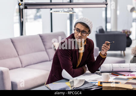 Vicenarian designer Holding Bleistift in der Hand während der Arbeit am Projekt Stockfoto