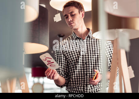Attraktive stilvollen Mann überraschend auf Verkauf Zeichen tag Stockfoto