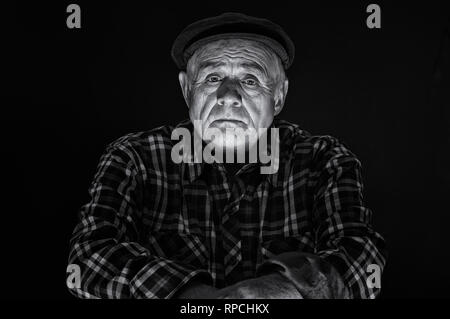 Schöne Schwarz-Weiß-Porträt der Kaukasischen älterer Mann in Gap - Low Key Stockfoto