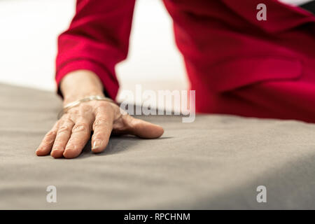Nahaufnahme der alternden Dame Hand liegend auf Bettwäsche Stockfoto
