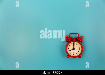 Rot Wecker auf blauem Hintergrund. Ansicht von oben. Flach. Stockfoto