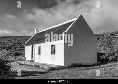 MATJIESRIVIER, SÜDAFRIKA, 27. AUGUST 2018: Ein historisches Haus mit Schilf Dach am Matjiesrivier in der cederberg Mountains. Schwarzweiß Stockfoto