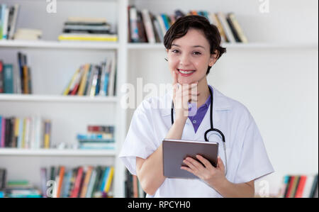 Lachen deutsche Krankenschwester mit Tablet Computer im Krankenhaus Stockfoto