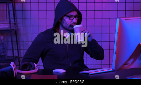 Männliche hooded Gamer gerade ein Spiel am Computer. Professionelle Aufnahme in 4K-Auflösung. 020. Sie können es verwenden, z. B. in ihrem kommerziellen Video, medizinische, Busines Stockfoto