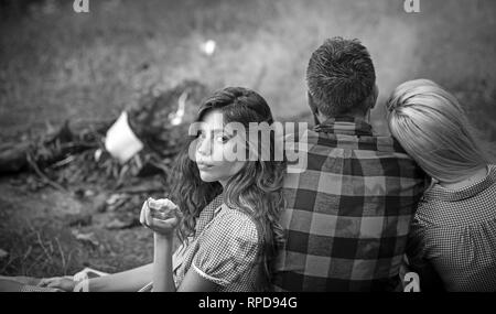 Eine Gruppe von Freunden mit Picknick im Sommer. Brunette Mädchen essen Green Apple während lehnte sich auf ihre Freundin. Vitamine, Gesundheit und Wohlbefinden Konzept Stockfoto