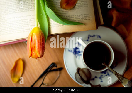 Tulip Blumen über Vintage Books in der Nähe einer Tasse Tee Stockfoto
