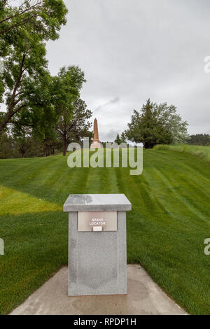 HOT SPRINGS, South Dakota - Juni 8, 2014: ein Granit Schreibtisch, der das Grab locator Buch hält mit einem Obelisk Denkmal im Hintergrund Hot Spring Stockfoto