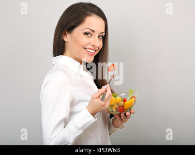 Schönen Lächeln, Geschäftsfrau gesund essen Bio vegatable Salat auf das Mittagessen auf blauem Hintergrund mit der leere Raum. Gesunde Ernährung am Arbeitsplatz ti Stockfoto
