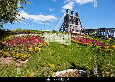 Blumen in der Form eines Schmetterlings mit den Ruinen eines Bergbau Stempel Mühle im Hintergrund in Butte, Montana gepflanzt Stockfoto