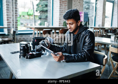 Smart junger asiatischer Mann Fotografen arbeiten mit Tablette während der Sitzung im Cafe. Stockfoto