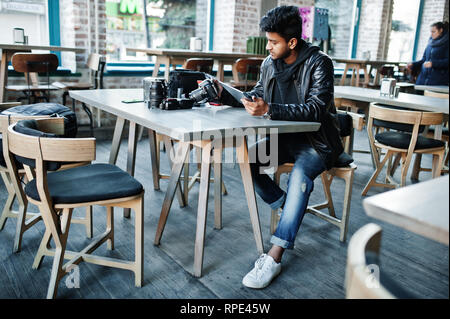 Smart junger asiatischer Mann Fotografen arbeiten mit Tablette während der Sitzung im Cafe. Stockfoto