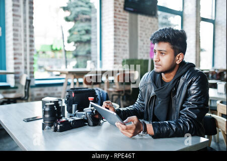 Smart junger asiatischer Mann Fotografen arbeiten mit Tablette während der Sitzung im Cafe. Stockfoto