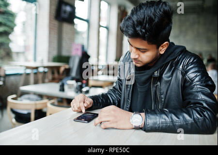 Asiatische Männer lässig Mann, Smartphone, Tippen auf Bildschirm sitzend auf Cafe. Stockfoto