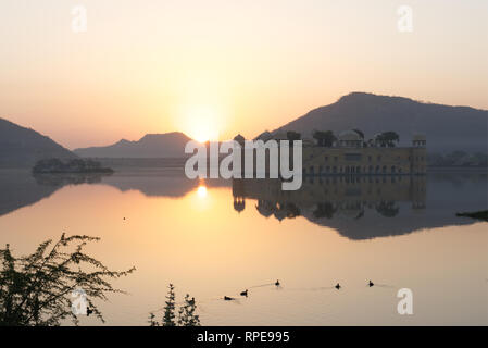 Atemberaubenden sonnenaufgang Kulisse für Jal Mahal Palace. Eine große architektonische Schaufenster der Rajput Stil im Menschen Sagar See wider. Stockfoto