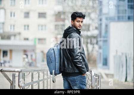 Elegante und lässige asiatischer Mann in schwarzem Leder Jacke mit Rucksack an der Straße gestellt hat. Stockfoto