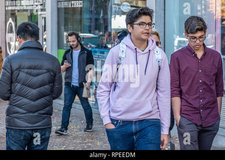Studenten zu Fuß entlang der Straße im Harvard Square in Cambridge, MA Stockfoto