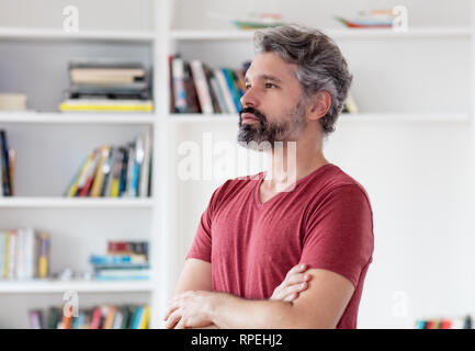 Denken deutschen im Mittleren alter Mann mit grauen Haaren drinnen zu Hause Stockfoto
