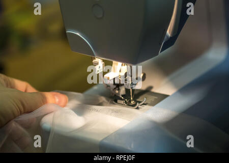 Nahaufnahme Mechanismus der Nähmaschine Fuß mit Nadel und Faden Stockfoto