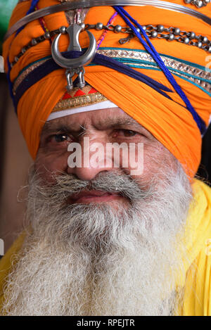 Bunte, turbaned Mann in der Guru ka Langar, eine kostenlose Sikh Küche, wo alle Besucher eine einfache Heilige Mahlzeit, Amritsar, Punjab, Indien, Asien gefüttert werden. Stockfoto