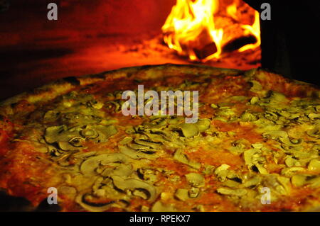 Kochen Pizza in professionellen Holzofen Stockfoto