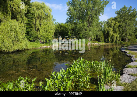Teich mit Steg und Pavillon im Frühling, Centre de la Nature, Saint-Vincent-de-Paul, Laval, Quebec, Kanada. Stockfoto