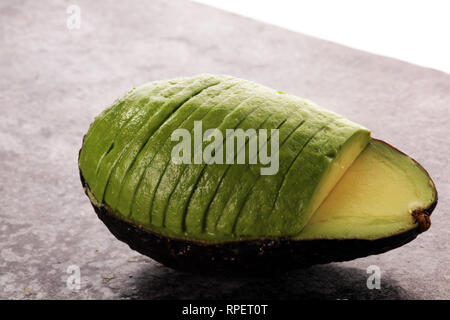 Avocado auf alten Tisch. Hälften der frische reife hass Avocado. Obst gesunde Ernährung Konzept Stockfoto