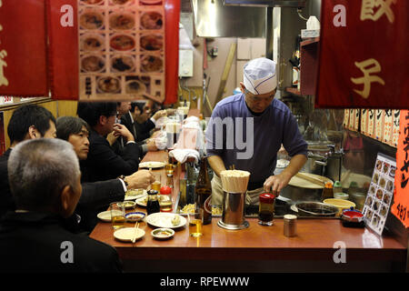 TOYKO, Japan - 05. Dezember 2016: Unbekannter japanischer cheff Vorbereitung der Gerichte für seine Klienten in einem Restaurant in Shinjuku in Toyko, Japan Stockfoto