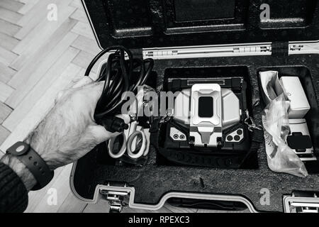 Techniker Vorbereitung der Moderne innovative und leistungsstarke aktive bekleidet - Ausrichtung Rollenwechsler für Spleißen eine Reihe von dünnen optischen Fasern-holding Power Kabel verwendet werden Stockfoto