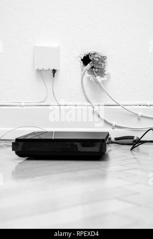 Lwl-Installation zu Hause mit veralteten CATV- und neue FTTH Fibre Outlets und internet Receiver auf Parkettboden Stockfoto