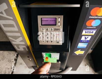 BASEL, SCHWEIZ - 22.MÄRZ 2018: die Sicht der männlichen Hand, denn eine Kreditkarte aus einem Parkplatz Teller Machine nach der Zahlung wird akzeptiert Stockfoto