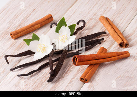 Vanille und Zimt mit Blume und Blatt auf einem weißen Holz- Hintergrund Stockfoto